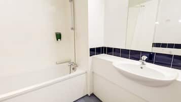 A modern bathroom with a bathtub, a sink, and a mirror.