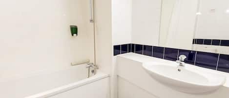 A modern bathroom with a bathtub, a sink, and a mirror.