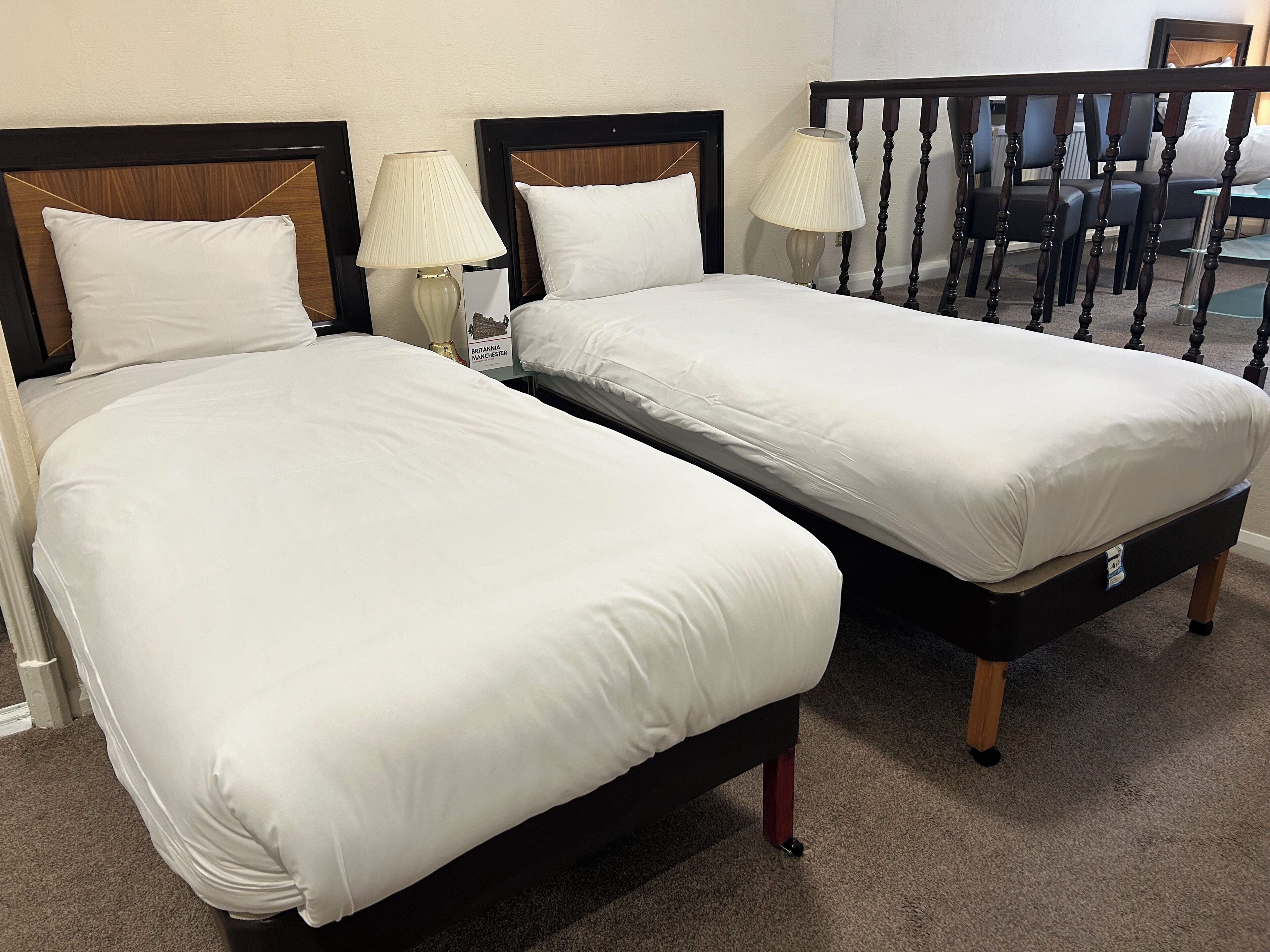 Two twin beds with white bedding, wooden headboards, and bedside lamps.