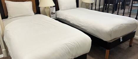 Two twin beds with white bedding, wooden headboards, and bedside lamps.