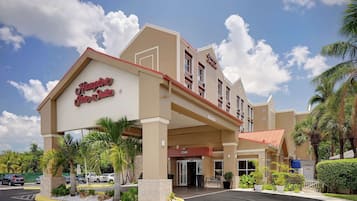 Un hotel con un letrero llamativo que dice "Hampton Inn & Suites".