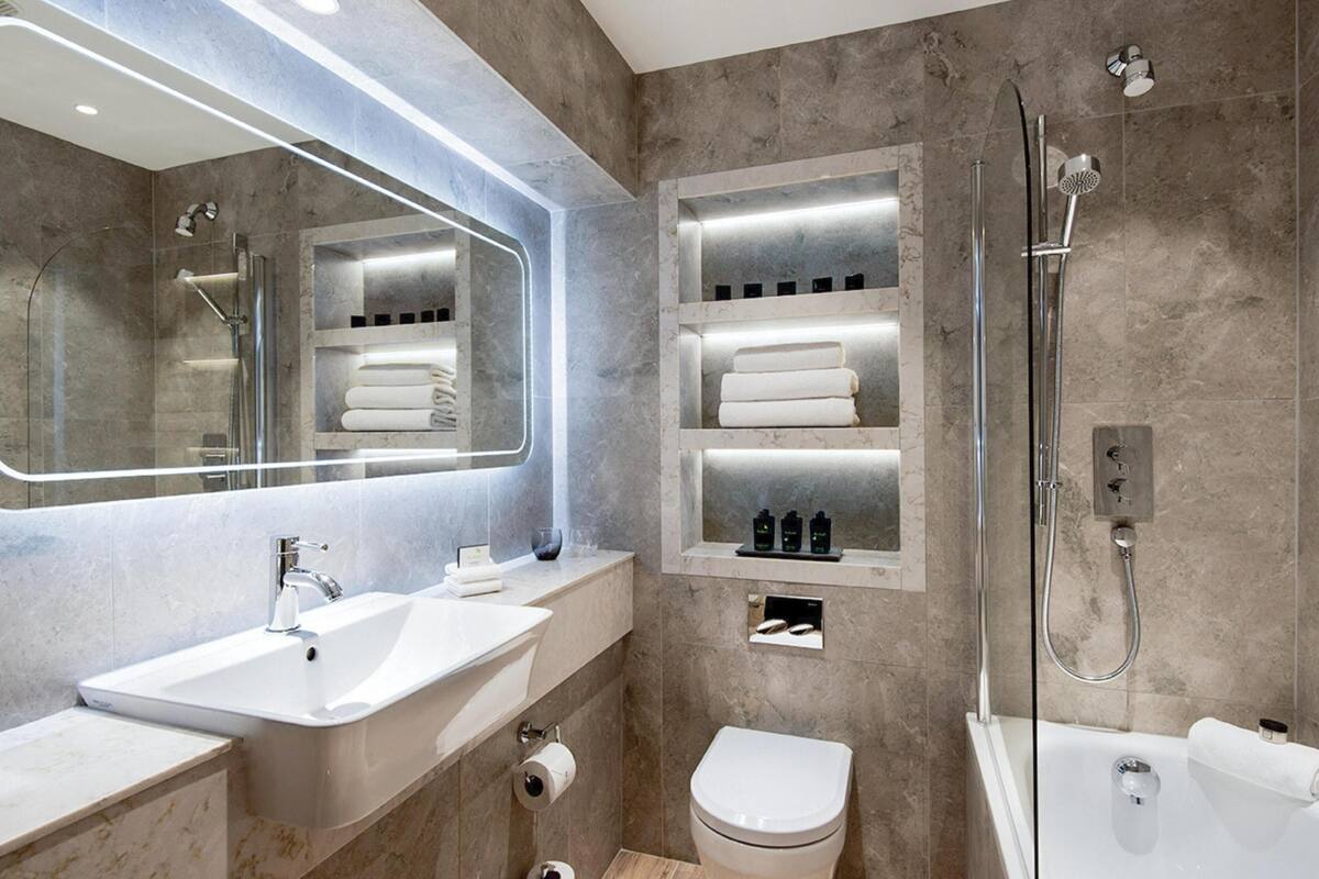 combined shower/bathtub, designer toiletries, hair dryer, towels