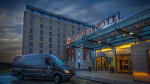 En hotelindgang med en varevogn parkeret foran.