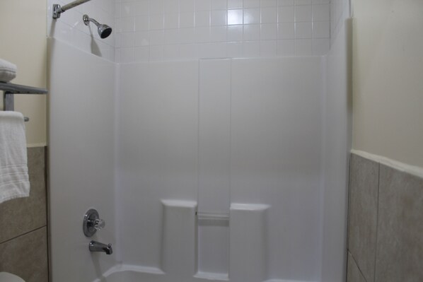 A bathroom with a shower, a toilet, and a towel rack.