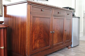A wooden cabinet with drawers and a microwave on top. - Staywell Hotel (Florida City)
