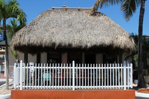 Un bâtiment avec un toit de chaume et une clôture blanche.