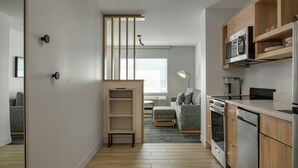 Eine moderne Küche mit Holzausstattung, einem Einbauofen und einer Mikrowelle.