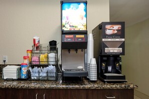 En kaffestation med en kaffemaskin, en juiceautomat och ett urval av olika kaffe- och tesorter.