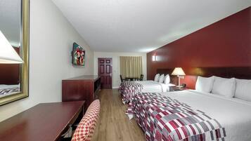 Una habitación de hotel con cama, escritorio, silla, televisor y puerta.