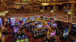 A casino with multiple slot machines, a grand staircase, and ornate decor.