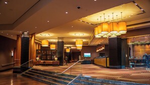A lobby with a staircase, seating area, and a reception desk.