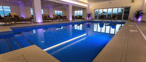 Piscine intérieure, chaises longues