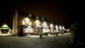 A large brick building with multiple windows and a central courtyard with outdoor seating. - Worcester Bank House Hotel Spa & Golf, BW Premier Collection (Worcester)