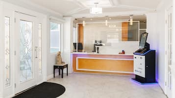 A reception area with a counter, a statue, and a NexTAP self-service kiosk.