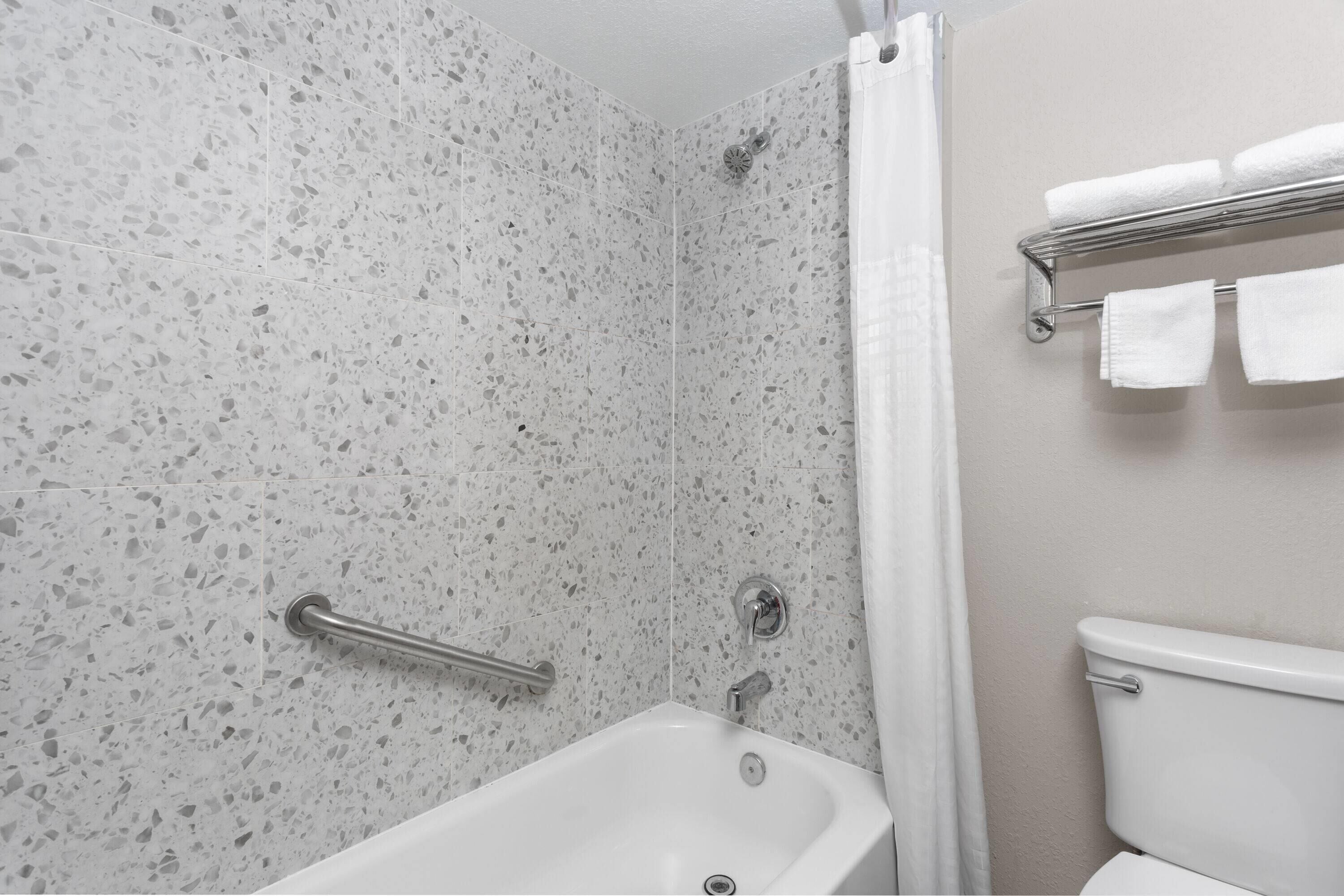 A bathroom with a bathtub, a shower, and a toilet.