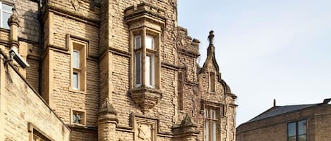 Un edificio histórico de piedra con ventanas arqueadas y una entrada destacada.