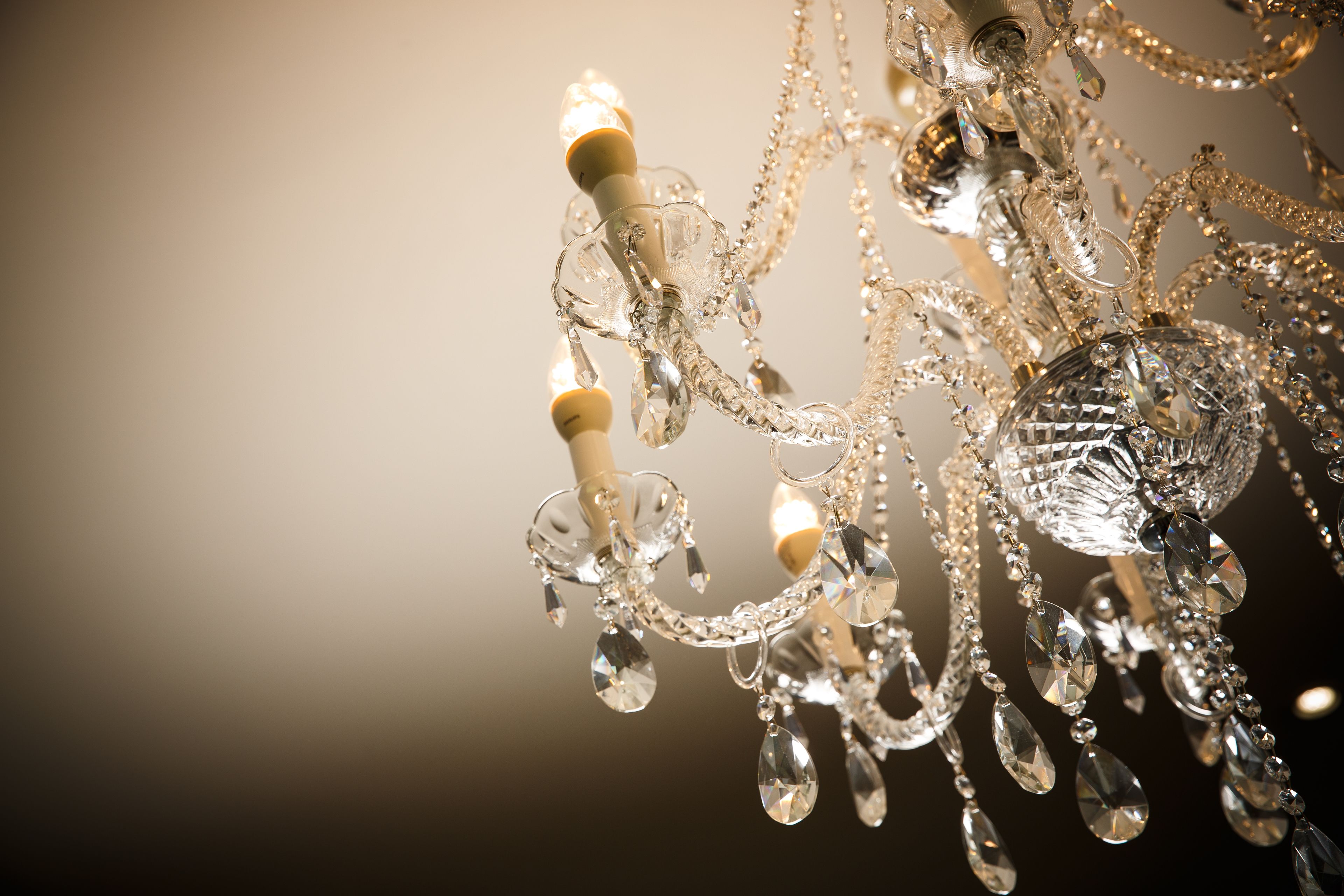 Un lustre orné de nombreux éléments de cristal et de plusieurs ampoules.