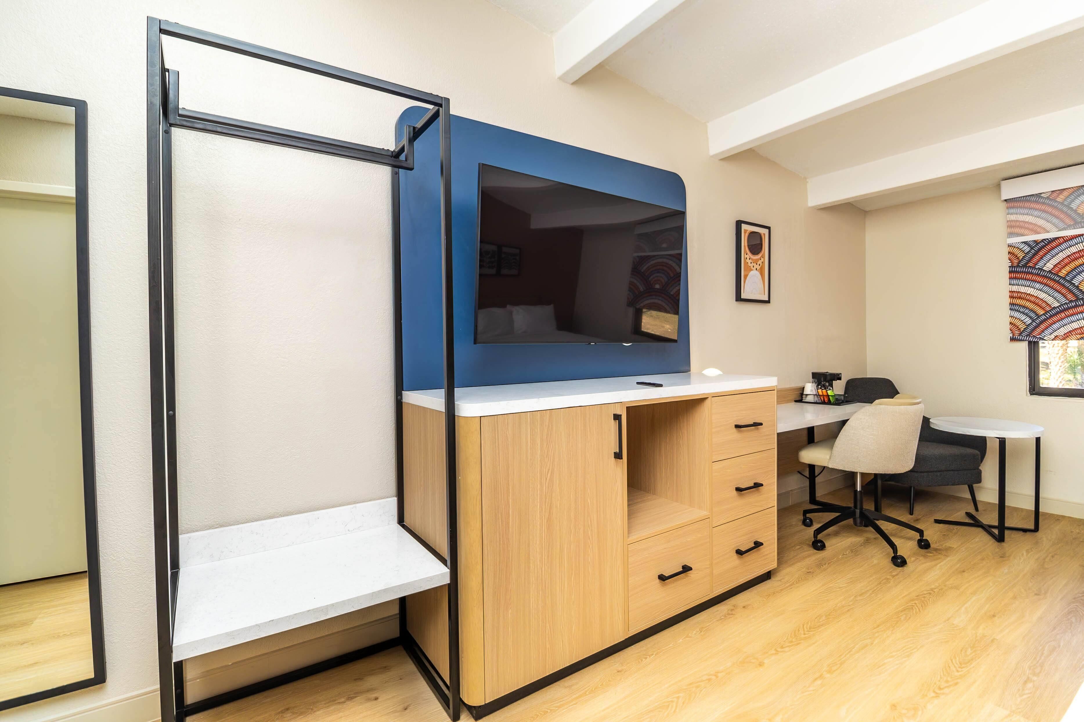 Une petite pièce comprenant un lit, un bureau et une chaise.