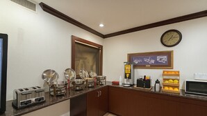 A kitchen with a microwave, toaster, and various food containers. - Ramada by Wyndham Davenport Orlando South (Davenport)