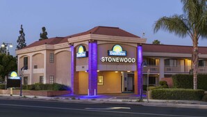 A Days Inn Stonewood building with a brick facade, arched windows, and a sign indicating a 40 mph speed limit. - Days Inn by Wyndham Downey (Downey)