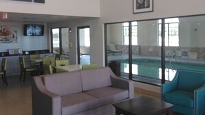 Un vestíbulo amplio con vista a la piscina, un comedor y un sofá.