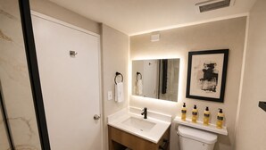 A bathroom with a white sink, mirror, and toilet. There are toiletries on the sink and a towel rack. - Best Western Plus Atlanta Sandy Springs Perimeter Hotel (Atlanta)