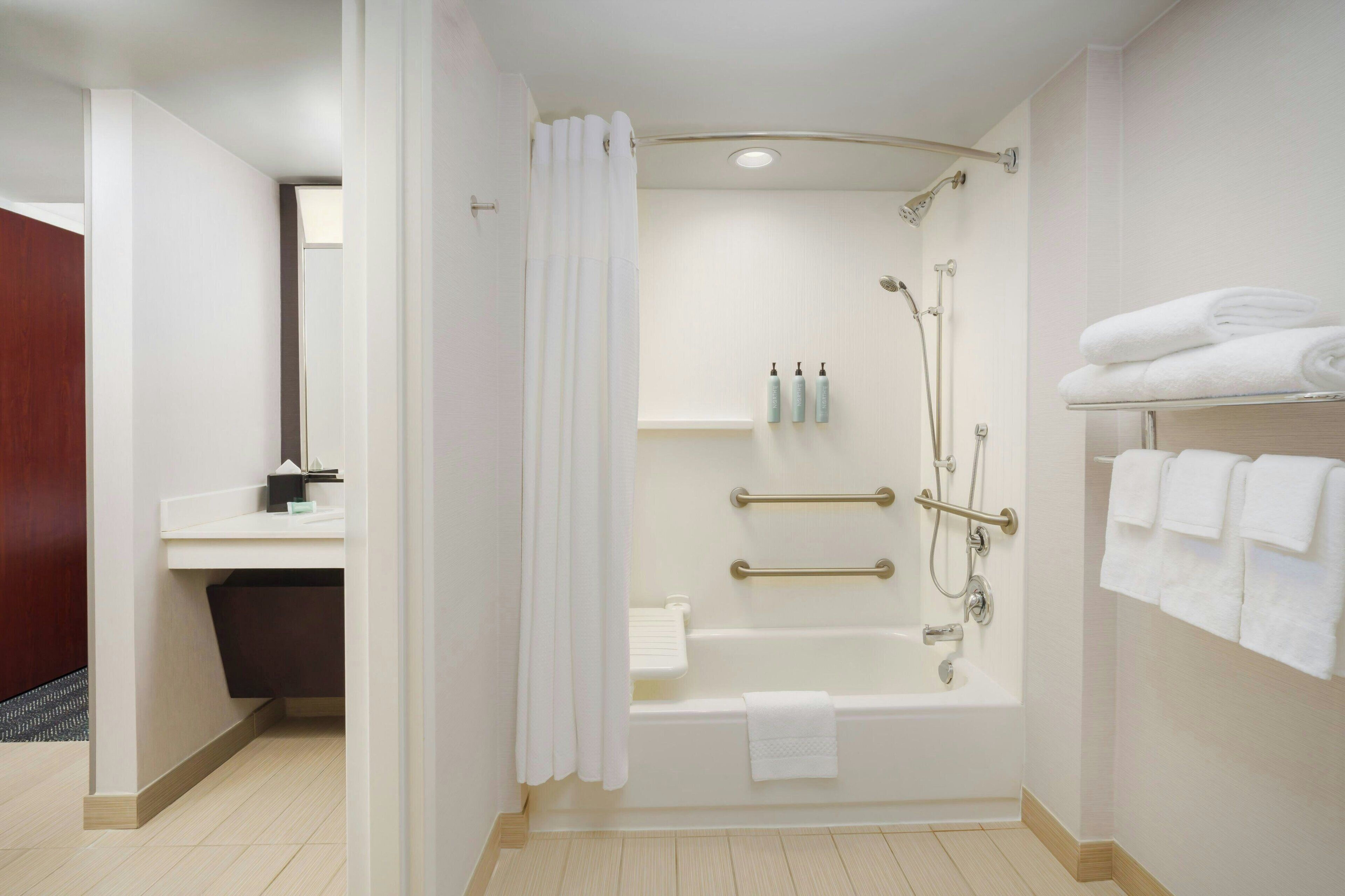 A modern bathroom with a bathtub, shower, and toilet.