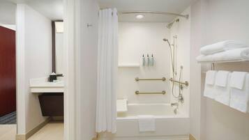 A modern bathroom with a bathtub, shower, and toilet.