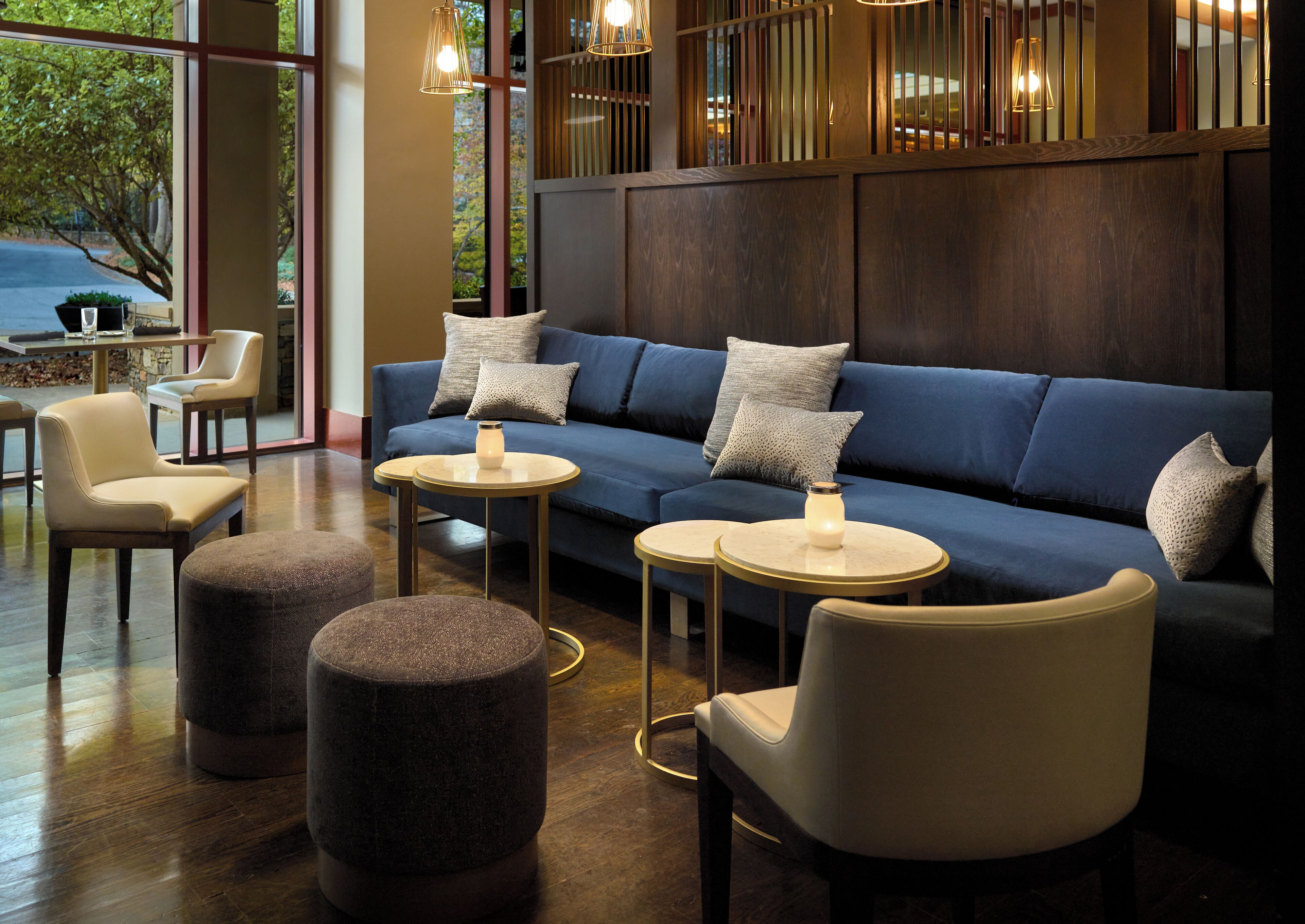 A modern lounge area with a blue sofa, two round tables, and a seating arrangement.