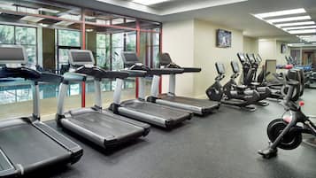 Ein Fitnessstudio mit Laufbändern, Crosstrainern und Ergometer.