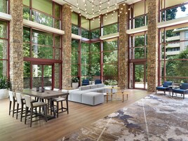 A spacious interior with a large dining table, seating area, and large windows offering views of the outdoors.