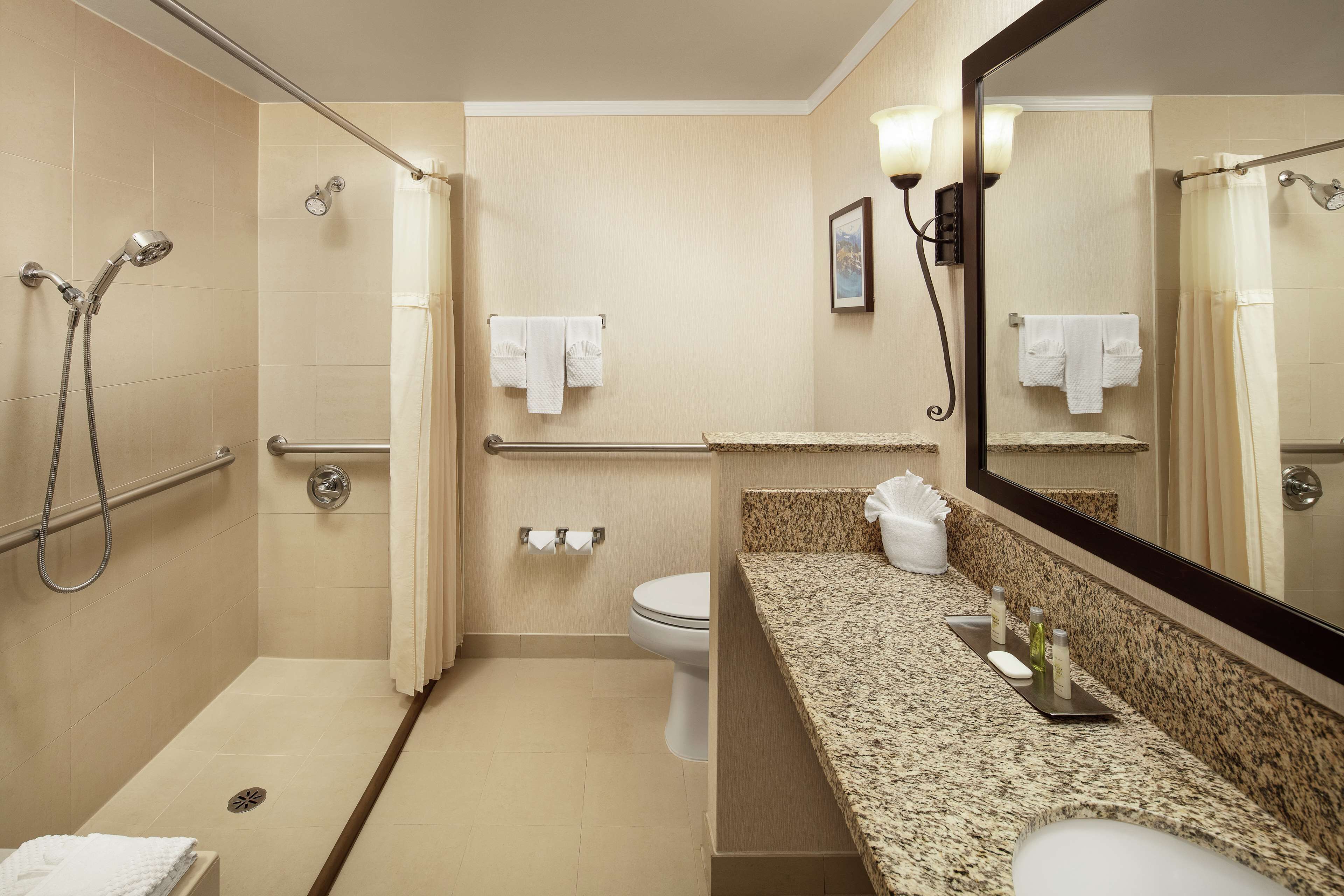 A modern bathroom with a shower, toilet, and sink.