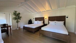 A hotel room with two beds, a desk, a chair, and a potted plant. - Carmel Resort Inn (Carmel)