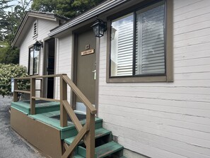 A two-story building with a front porch and a staircase.