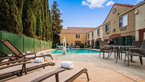 A pool area with lounge chairs and a diving board. - Best Western Brentwood Inn (Brentwood)