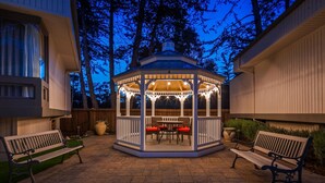 A gazebo with a table and chairs, surrounded by a brick patio and wooden benches. - Best Western The Inn & Suites Pacific Grove (Pacific Grove)