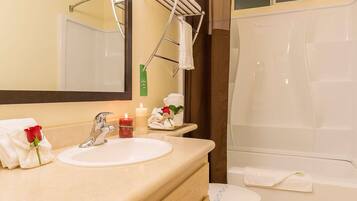 A bathroom with a sink, mirror, and towel rack.