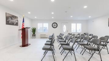 A conference room with a podium, American flag, and a word cloud on the wall.