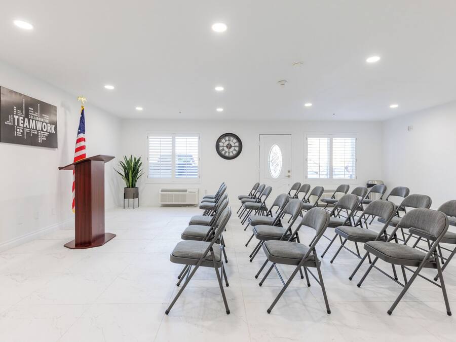 A conference room with a podium, American flag, and a word cloud on the wall.