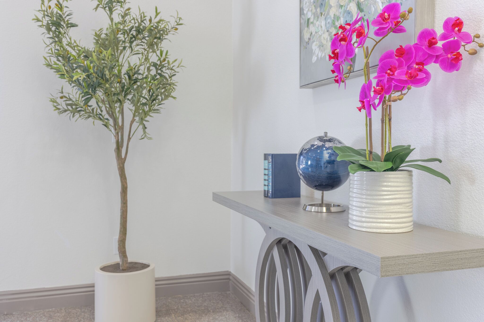 A potted plant, a globe, and a vase with flowers on a shelf.