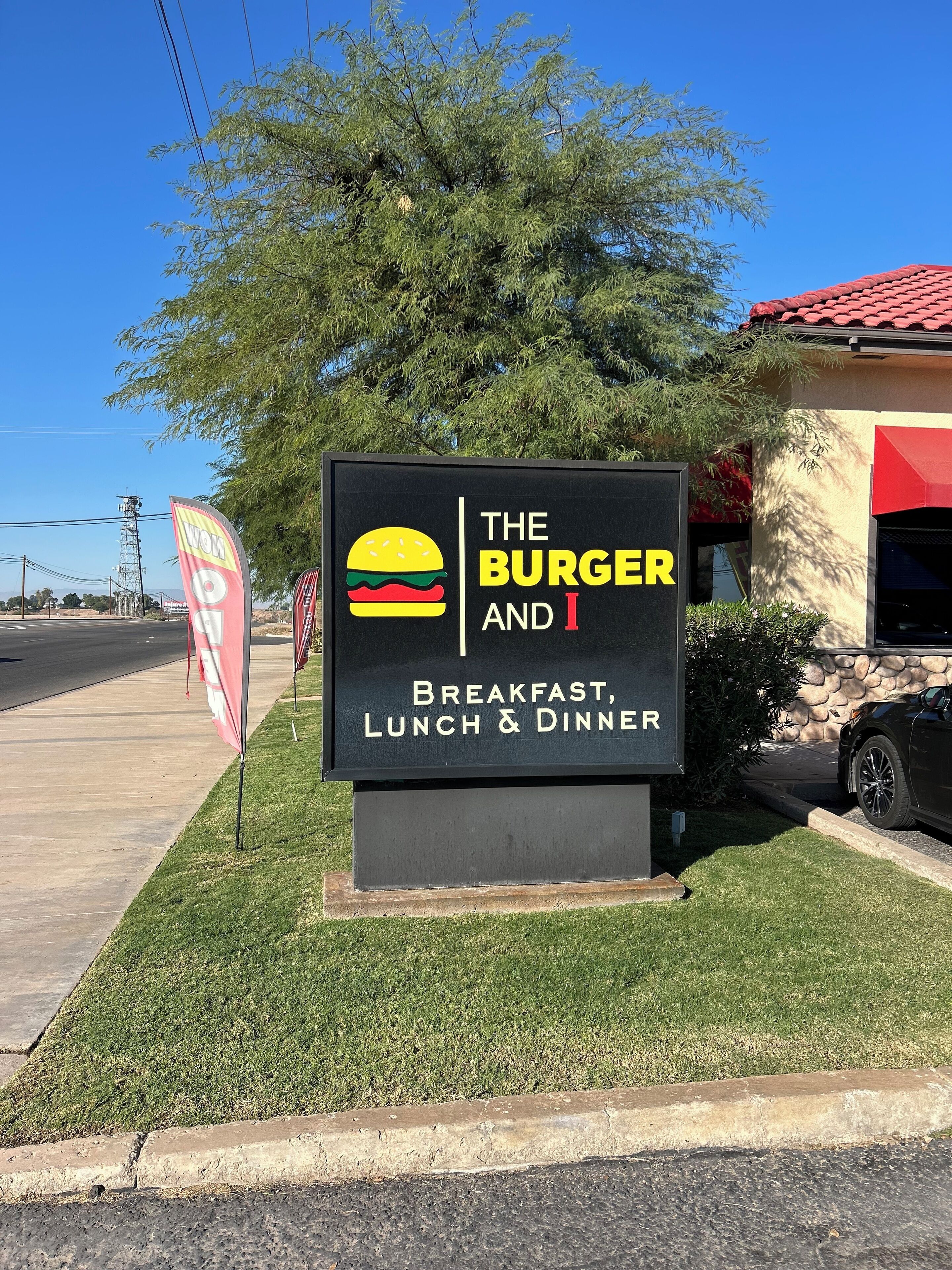 A sign for 'The Burger and I' restaurant, indicating it serves breakfast, lunch, and dinner.