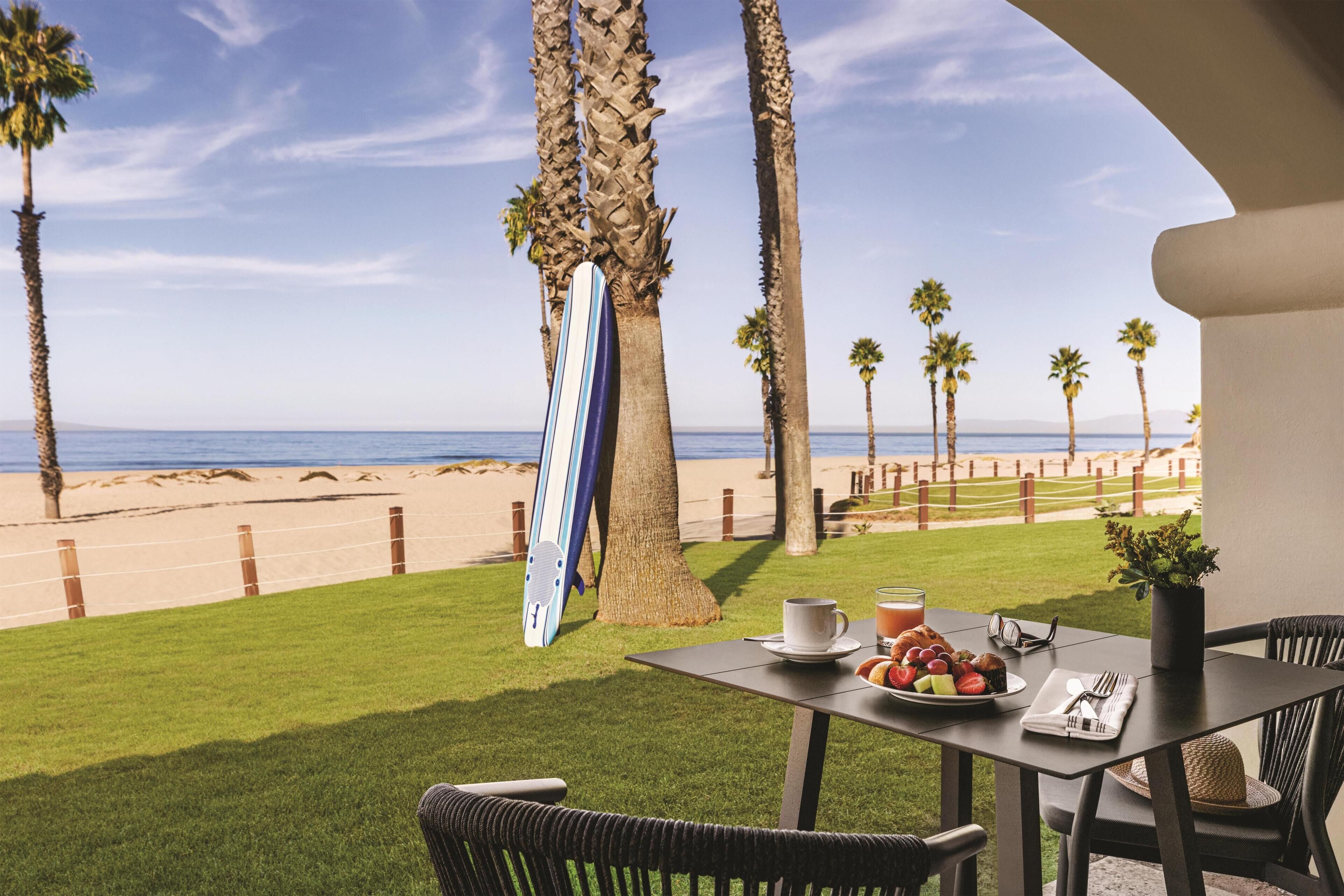 Ein Tisch ist für ein Frühstück gedeckt, mit Blick auf Strand und Meer.