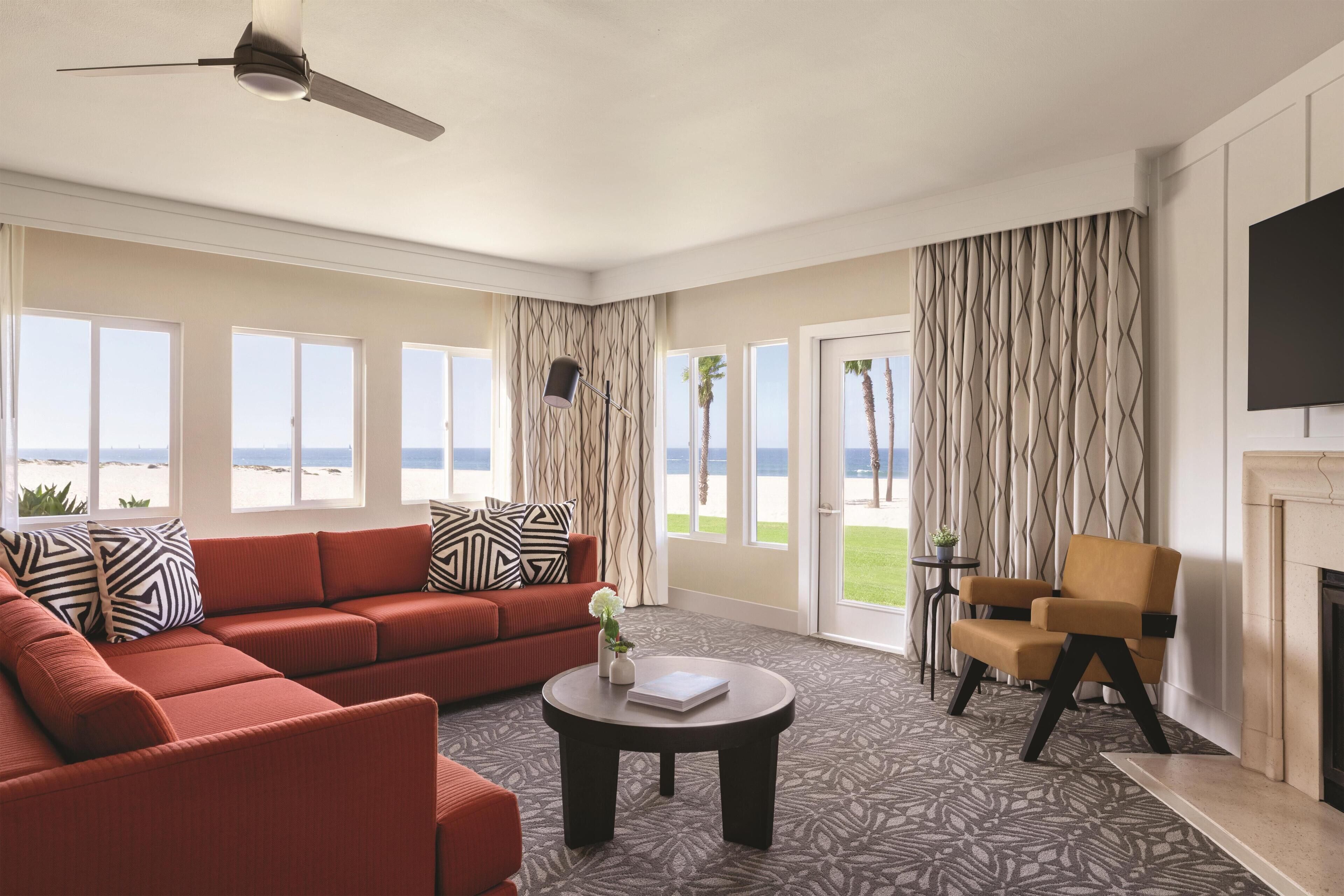 A living room with a red sofa, a round coffee table, and a fireplace.
