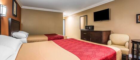 Habitación de hotel con dos camas, televisión, escritorio y silla.