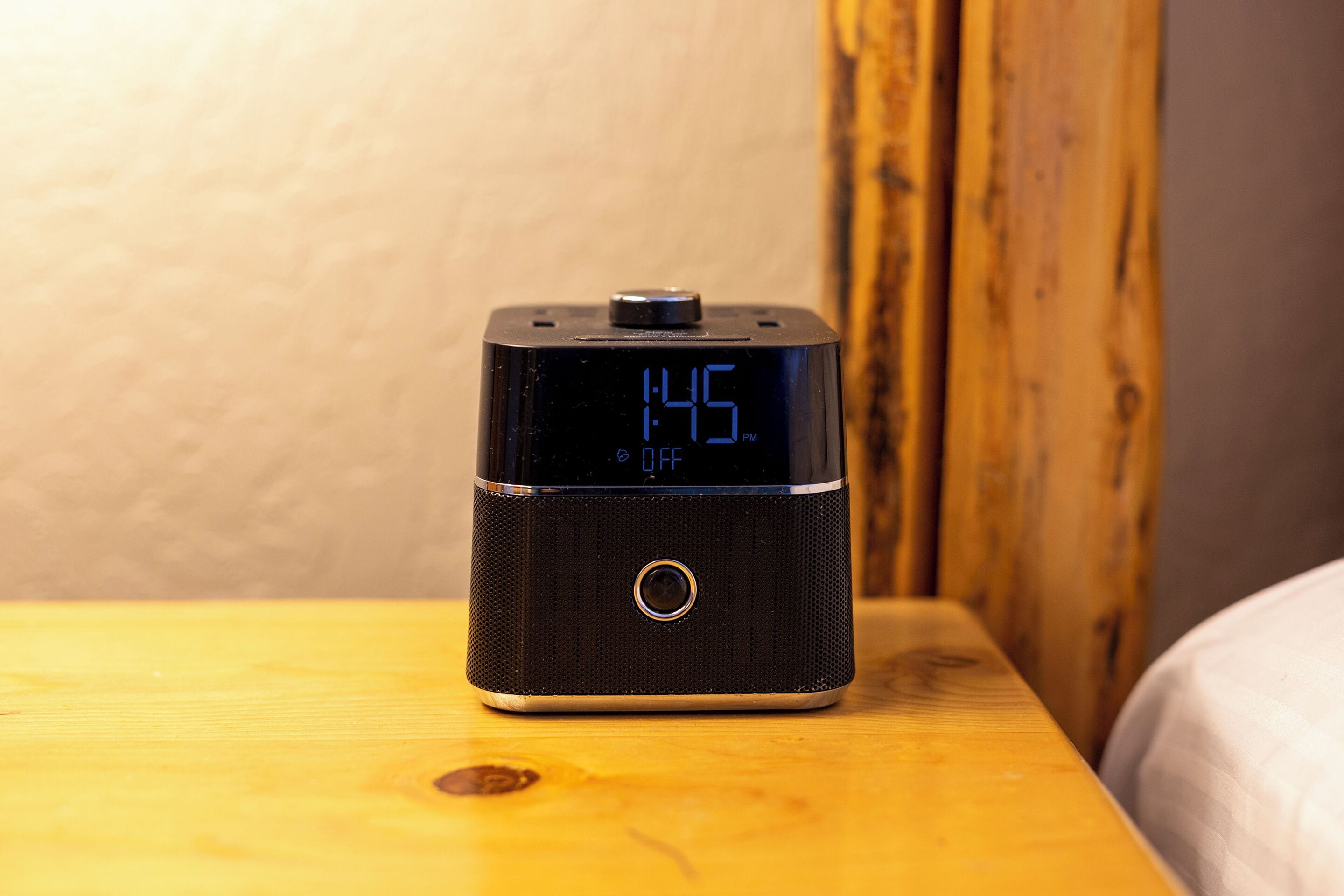 Een digitale klok met de tijd 14:45 uur, met een UIT-indicator, op een houten ondergrond.