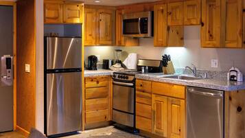 A kitchen with wooden cabinets, stainless steel appliances including a refrigerator, microwave, stove, and dishwasher.