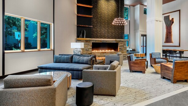A spacious living area with a fireplace, comfortable seating, and large windows offering views of the outdoors.