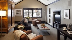 Una sala de estar con un sofá, sillones, una mesa de centro, un televisor y una chimenea.