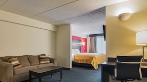 A hotel room with a sofa, a bed, a desk, and a chair. - Quality Suites Atlanta Airport East (Forest Park)