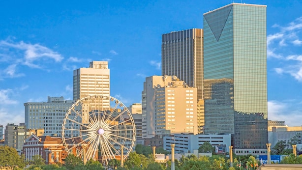 A cityscape with a large Ferris wheel, modern high-rise buildings, and a clear blue sky. - Quality Suites Atlanta Airport East (Forest Park)